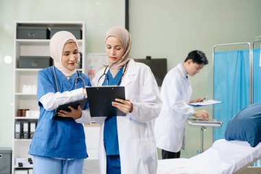 Doktorlar ve hemşireler hastane koğuşunda birlikte çalışıyorlar, profesyonellik ve takım çalışması sergiliyorlar.