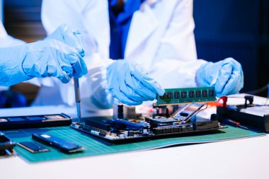 Laboratuvar önlüklü işçiler elektronik montaj ve yüksek teknolojili RAM kurulumu yapıyorlar. Gelişmiş teknoloji ve bilgisayar mühendisliği kavramlarını sergilemek için ideal.