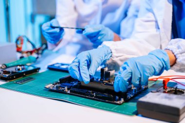 Laboratuvar önlüklü işçiler elektronik montaj ve yüksek teknolojili RAM kurulumu yapıyorlar. Gelişmiş teknoloji ve bilgisayar mühendisliği kavramlarını sergilemek için ideal.