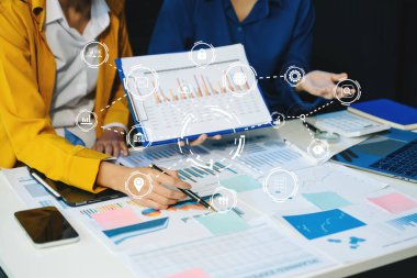 Takım çalışması. Yeni bir başlangıç projesi üzerinde çalışan genç iş adamları. Proje yöneticileri ofiste sanal ekranla planları ve belgeleri analiz ederler