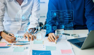 Takım çalışması. Yeni bir başlangıç projesi üzerinde çalışan genç iş adamları. Proje yöneticileri ofiste sanal ekranla planları ve belgeleri analiz ederler