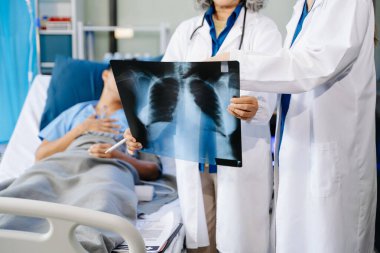 Profesyonel Asyalı doktorlar, modern hastanedeki gelişmiş ekipmanlı hastaların röntgen sonuçlarını açıklıyor. 