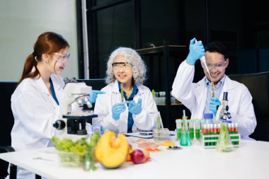 Bir laboratuarda mikroskop ve laboratuvar ekipmanları kullanarak yiyecek araştırması yapan Asyalı bilim adamları ekibi, gıda bilimi ve biyoteknoloji alanında yenilik sergiliyor.