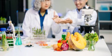 Laboratuvar önlüklü gıda bilimcileri, numuneleri test ediyor ve modern bir laboratuvar ortamında gıda güvenliği ve kalitesini analiz ediyorlar..