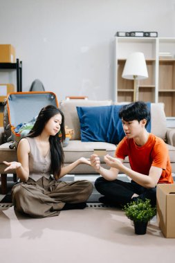 Asyalı genç ve çekici bir çift yeni eve taşınıyor ve ellerinde alışveriş için kredi kartı var. Genç evli Asyalı eve taşınıyor..