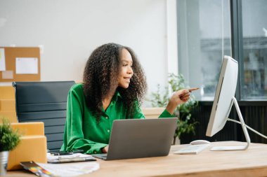 Başlangıçta küçük işletme KOBİ 'si, yeni siparişleri kontrol etmek için bilgisayar ve laptop kullanan girişimci kadın, çevrimiçi alışveriş kavramı, karton kutular
