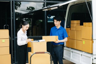 Express Teslimat Servisi. Asyalı kurye bayan müşteriye paket teslim ediyor. Deponun dışında kargo servisi, eve teslimat ve nakliye konsepti.