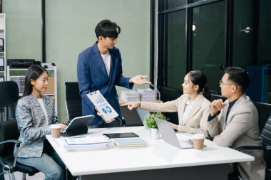  Genç iş adamları beyin fırtınası yapıyor, bilgisayar ve tablet kullanarak iş planlıyorlar ve tartışıyorlar.