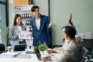  Genç iş adamları beyin fırtınası yapıyor, bilgisayar ve tablet kullanarak iş planlıyorlar ve tartışıyorlar. İş adamları el kol hareketi yapıyor. 