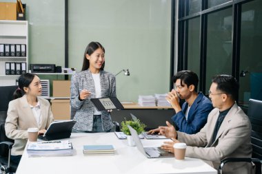  Genç iş adamları beyin fırtınası yapıyor, bilgisayar ve tablet kullanarak iş planlıyorlar ve tartışıyorlar.