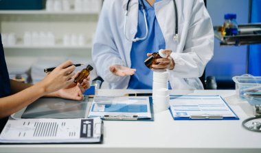 Laboratuvar önlüklü doktorların orta kesimi klinik ortamlarda ilaçlar, takım çalışması ve sağlık hizmetlerinde işbirliği konularını tartışıyor..