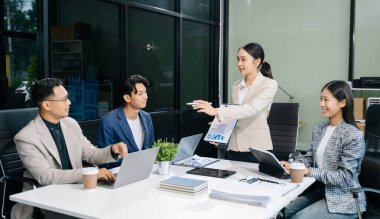  Genç iş adamları beyin fırtınası yapıyor, bilgisayar ve tablet kullanarak iş planlıyorlar ve tartışıyorlar.