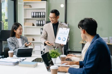  Genç iş adamları beyin fırtınası yapıyor, bilgisayar ve tablet kullanarak iş planlıyorlar ve tartışıyorlar.