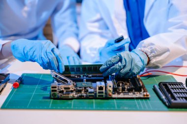 Laboratuvar önlüklü işçiler elektronik montaj ve yüksek teknolojili RAM kurulumu yapıyorlar. Gelişmiş teknoloji ve bilgisayar mühendisliği kavramlarını sergilemek için ideal.