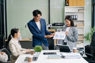  Genç iş adamları beyin fırtınası yapıyor, bilgisayar ve tablet kullanarak iş planlıyorlar ve tartışıyorlar.