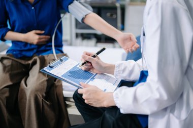 Erkek doktorun orta bölümü hastane yatağındaki kadın hastaya teşhisi açıklar. 