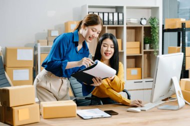 Küçük işletmeler kuran KOBİ sahipleri çevrimiçi siparişleri kontrol ediyor ve ev ofisindeki bilgisayarda çalışan ürünleri satıyor 