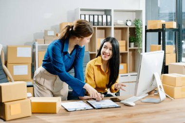 Küçük işletmeler kuran KOBİ sahipleri çevrimiçi siparişleri kontrol ediyor ve ev ofisindeki bilgisayarda çalışan ürünleri satıyor 