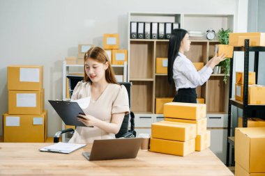 Küçük bir işe başlıyorum. KOBİ sahipleri çevrimiçi siparişleri kontrol ediyor, ürünler satıyor, ofiste kutularla dizüstü bilgisayarda çalışıyor