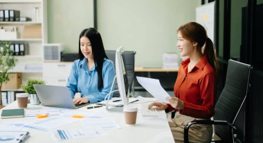 Bilgisayar ve dizüstü bilgisayar kullanan Asyalı iş arkadaşları. Modern ofiste çalışan finansal pazarlama ekibi. 