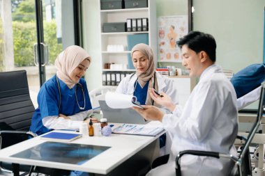 Klinikte panosu olan genç Müslüman doktor..