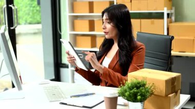 Küçük işletme KOBİ 'si kurun. İş kadını, çevrimiçi alışveriş siparişini almak ve kontrol etmek için tablet bilgisayar kullanıyor.