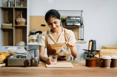 Profesyonel Asyalı barista kafede yüksek kaliteli fasulyelerle taze espresso yapıyor.