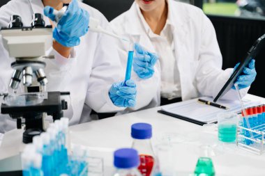 Modern tıbbi araştırma laboratuvarı. Kadın bilim adamı elleri, biyokimyasal örnekleri analiz eden mikro pipetlerle çalışıyor. Tıp için ileri bilim kimya laboratuvarı..