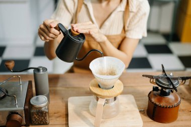 Profesyonel Asyalı barista kafede yüksek kaliteli fasulyelerle taze espresso yapıyor.