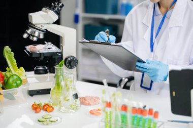 Laboratuar bilimcileri gelişmiş teknoloji ve hassas ekipman kullanarak sebzeleri güvenlik ve kalite için test edip analiz ediyorlar.