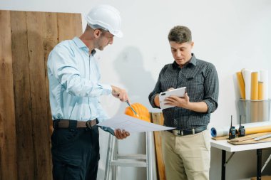 Mimarlar ve tasarımcılar modeller ve planlar üzerinde işbirliği yapıyorlar, yenilikçi yapılar üzerinde beyin fırtınası yapıyorlar ve modern bir ofiste kentsel gelişim planlıyorlar..