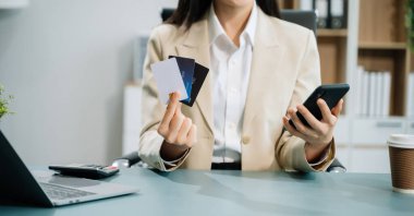 Ofiste kredi kartı ve akıllı telefon kullanan bir girişimci. 