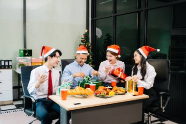 Noel 'i iş arkadaşlarınla neşeli bir ofis partisinde kutlamak, hediyeleri, kahkahaları ve tatil neşesini paylaşmak.