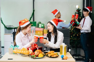 Noel 'i iş arkadaşlarınla neşeli bir ofis partisinde kutlamak, hediyeleri, kahkahaları ve tatil neşesini paylaşmak.
