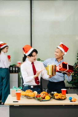 Noel 'i iş arkadaşlarınla neşeli bir ofis partisinde kutlamak, hediyeleri, kahkahaları ve tatil neşesini paylaşmak.