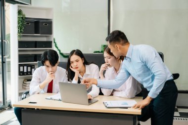 Ofiste yeni bir projede işbirliği yapan iş adamları. Ofiste dizüstü bilgisayar kullanan bir grup iş adamı..