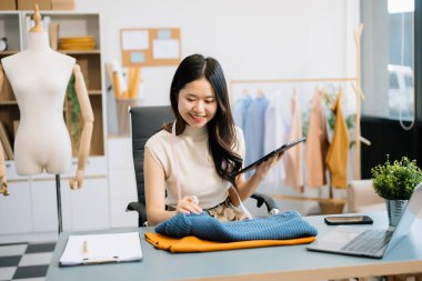 Başarılı bir moda tasarımcısı. Atölyede çalışan çekici Asyalı kadın..
