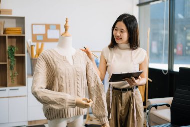 Başarılı bir moda tasarımcısı. Atölyede çalışan çekici Asyalı kadın..