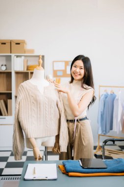 Başarılı bir moda tasarımcısı. Atölyede çalışan çekici Asyalı kadın..