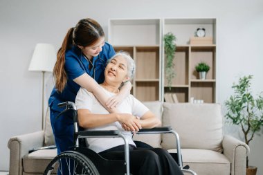 Genç hemşire, tekerlekli sandalyedeki yaşlı kadına yardım ediyor. Tedavi ve rehabilitasyon konsepti, kıdemli bakım 