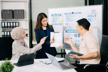 Bir grup Asyalı iş adamı yaratıcı iş planlama toplantısı ofiste dijital tabletler ve dizüstü bilgisayarlar kullanarak iş tartışması yapıyorlar.