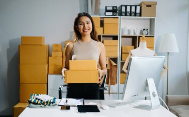 Kutuları tutan genç bir işletme sahibi - müşteriye teslimat emirleri