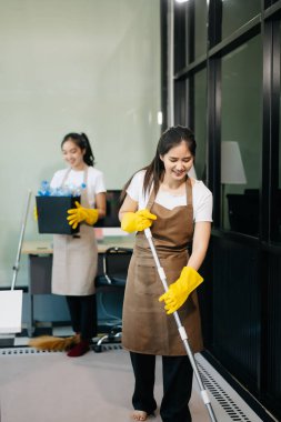 Verimli ve profesyonel temizlikçiler odayı temizliyor.