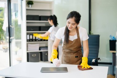 Verimli ve profesyonel temizlikçiler odayı temizliyor.