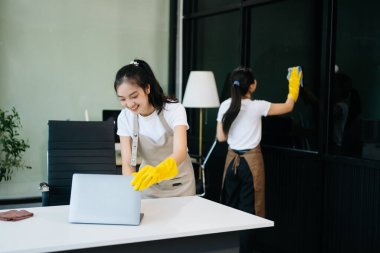 Verimli ve profesyonel temizlikçiler odayı temizliyor.