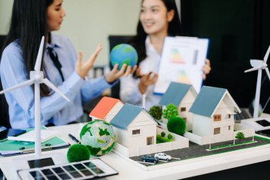 Daha yeşil bir gelecek için genç profesyoneller tarafından sürdürülebilir bir yenilik. Güneş panelleri, rüzgar türbinleri ve model evler ile yenilenebilir enerji çözümleri gösteriliyor