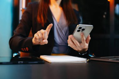 Ofiste akıllı telefon, dizüstü bilgisayar ve tablet kullanan bir iş kadını. Şirket, teknoloji ve modern iş konsepti için mükemmel.