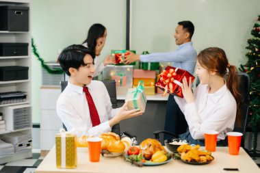 Meslektaşlar Noel 'i neşeli bir ofis partisinde kutluyor, hediyelerini paylaşıyor, gülüyor ve tatil neşesini ofislerinde paylaşıyorlar.