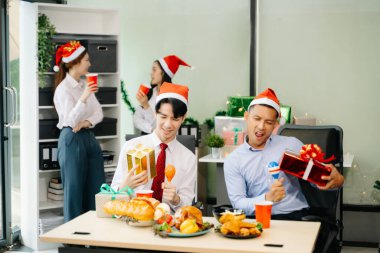 Meslektaşlar Noel 'i neşeli bir ofis partisinde kutluyor, hediyelerini paylaşıyor, gülüyor ve tatil neşesini ofislerinde paylaşıyorlar.