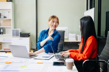 Dizüstü bilgisayar kullanan Asyalı iş arkadaşları. Modern ofiste çalışan finansal pazarlama ekibi. 